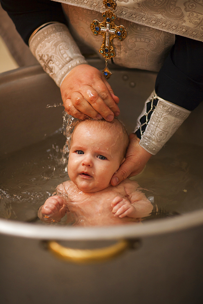 Caucasian baby boy being baptized