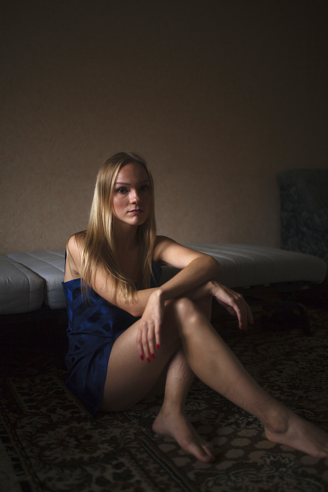 Portrait of serious Caucasian woman resting on floor