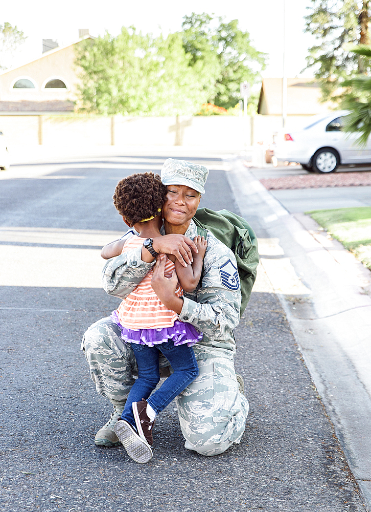 Black woman soldier greeting daughter in street