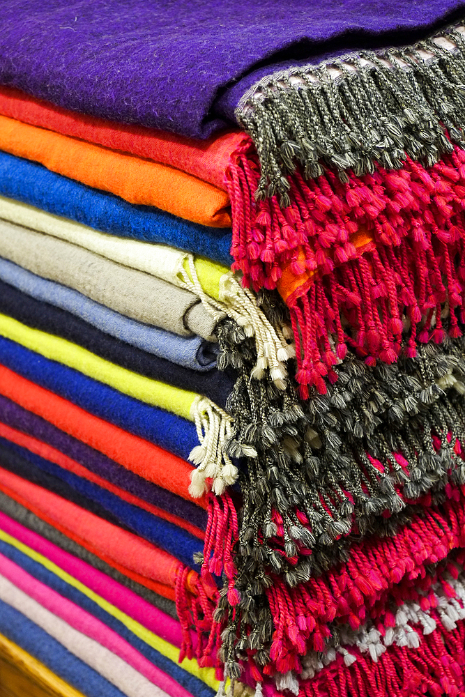 Piles of multicolor blankets with fringe