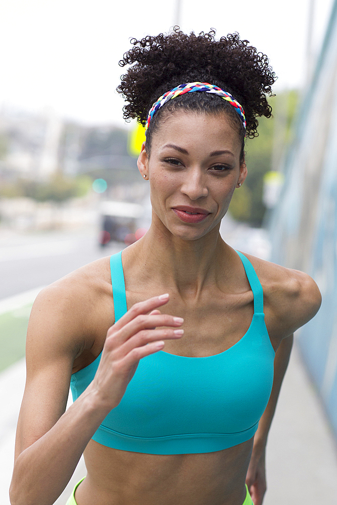 Mixed Race woman running on sidewalk