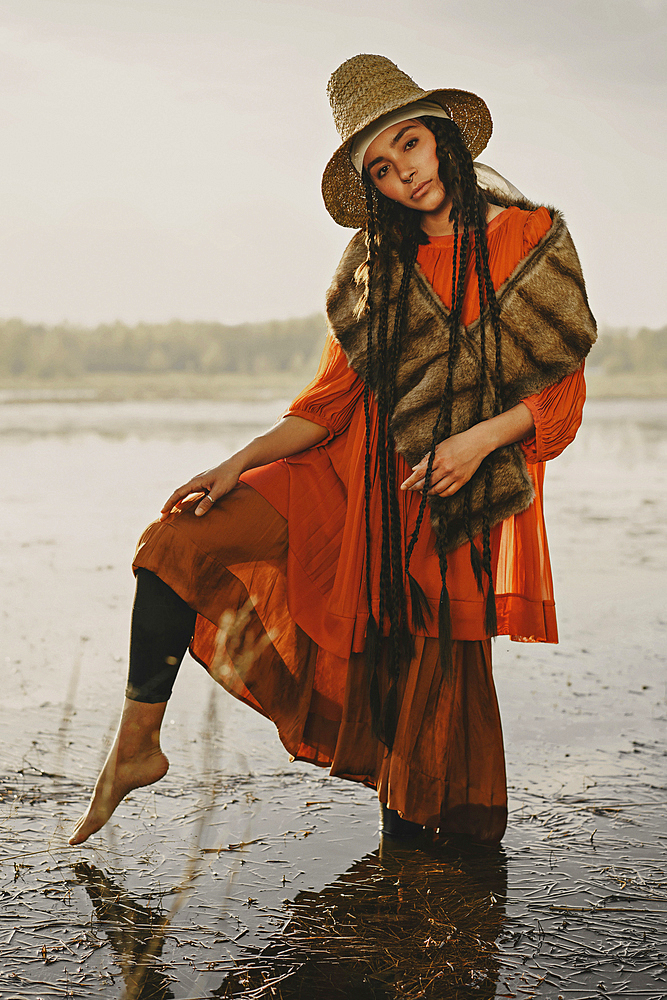 Caucasian woman wearing traditional clothing wading in water