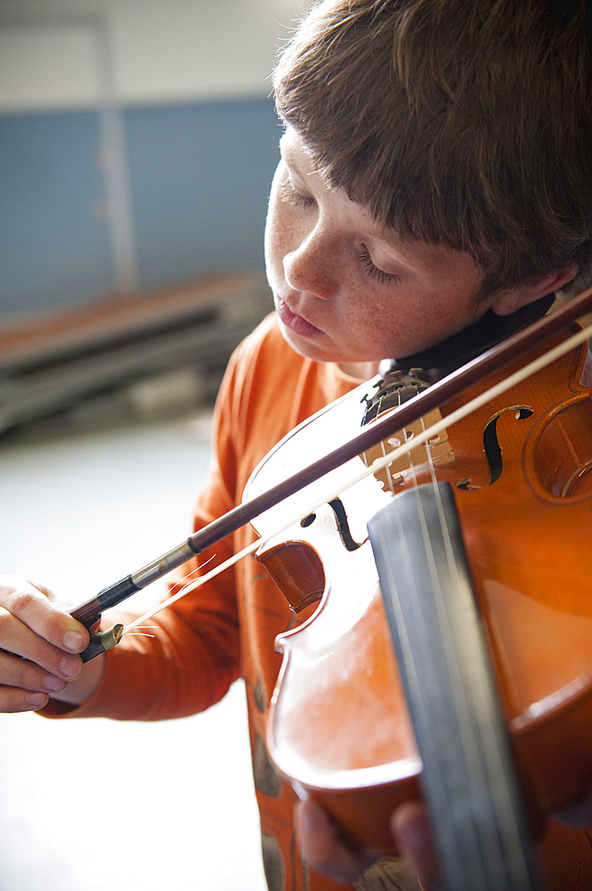 Close up of Caucasian boy practicing violin