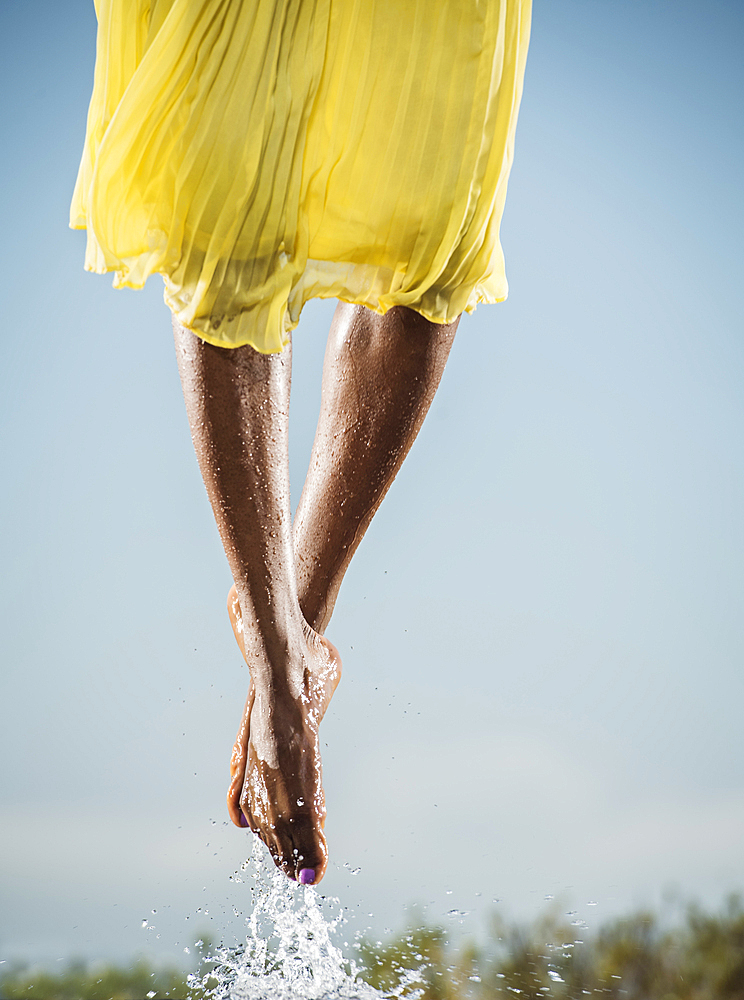 Feet of Black dancing jumping in water