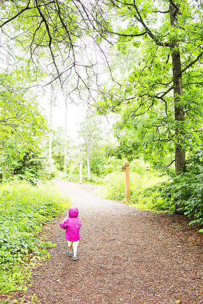 Caucasian girl walking on path in forest