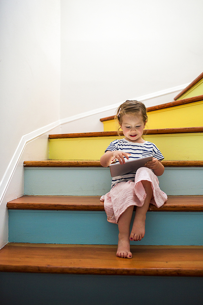 Caucasian girl using digital tablet on staircase