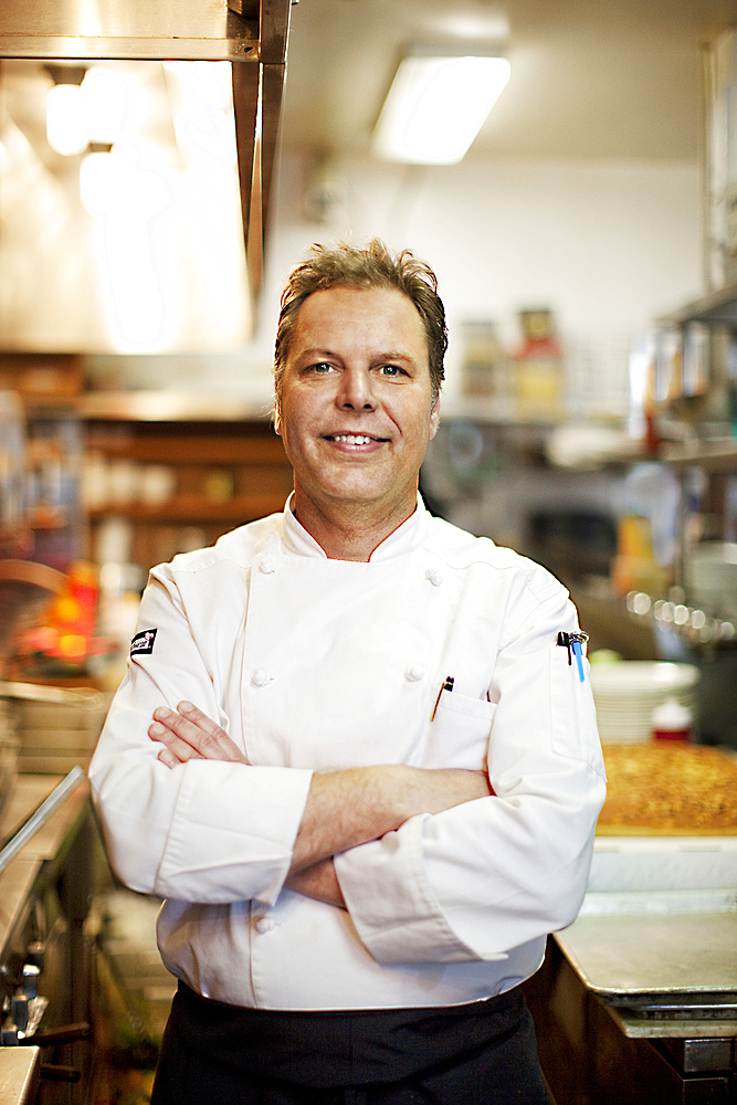 Confident Caucasian chef standing in commercial kitchen