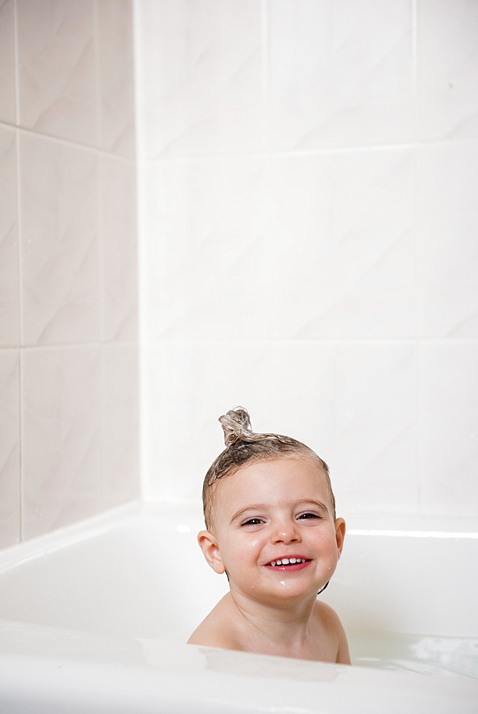 Smiling Caucasian girl in bubble bath