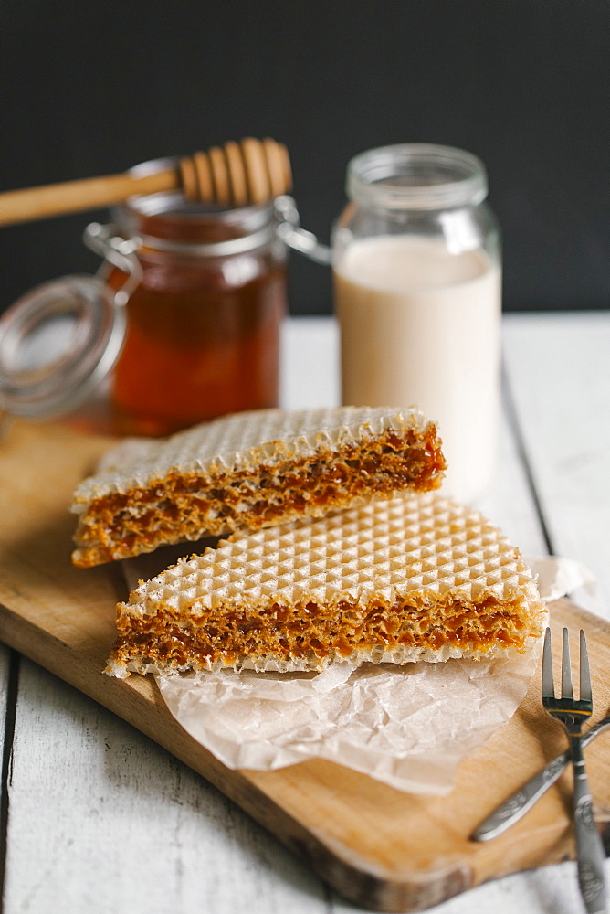 Dessert on cutting board with milk and honey