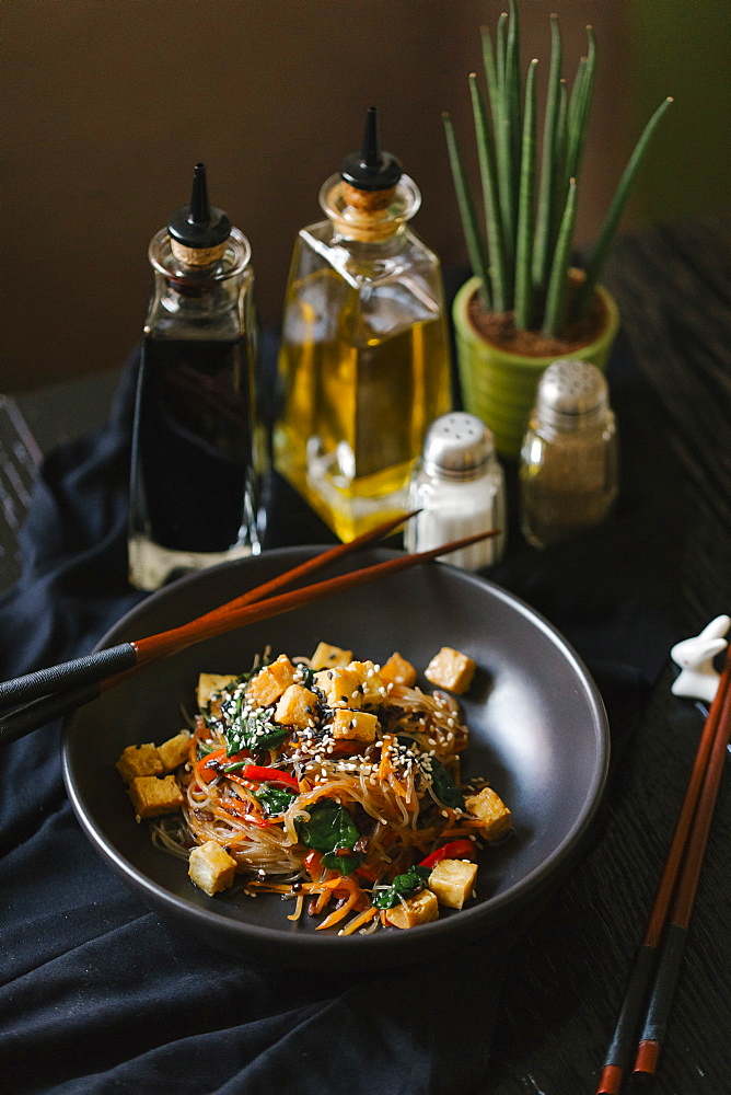 Chopsticks on the bowl with noodles and tofu