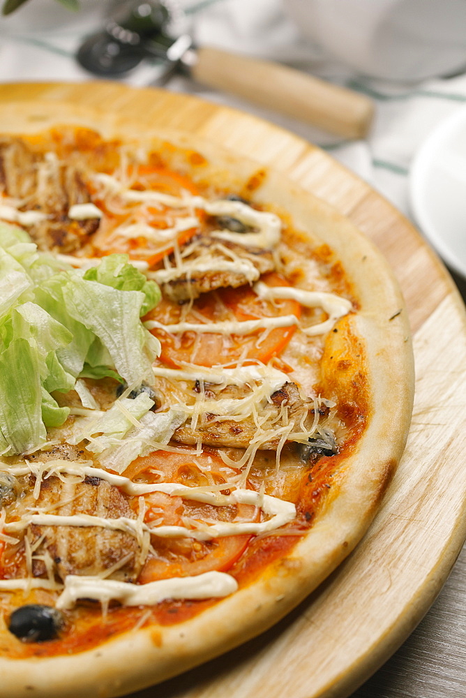 Close up of lettuce and tomatoes on pizza