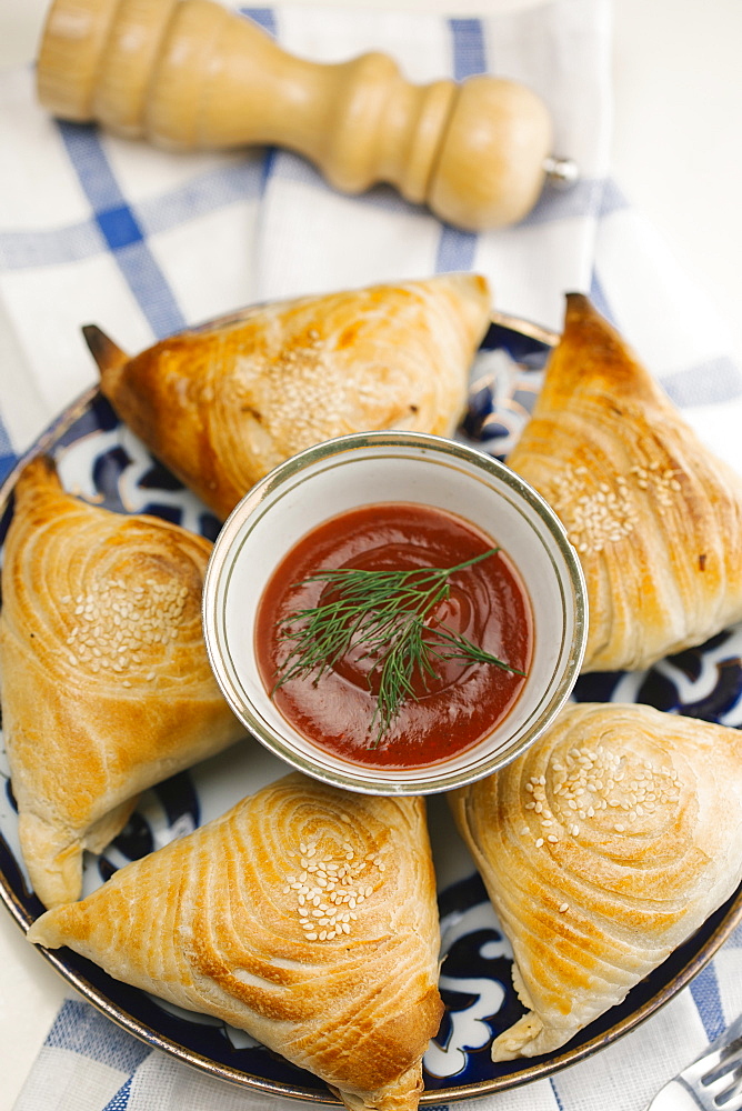 Pastry with sesame seeds on plate with sauce