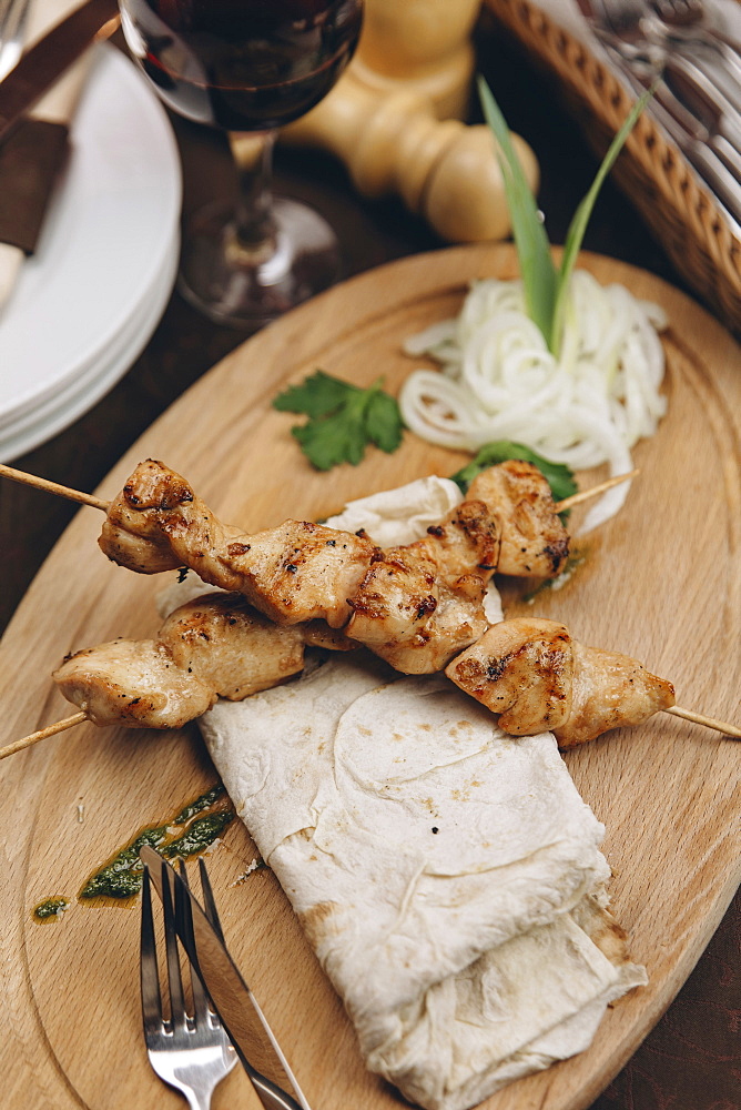 Meat on skewers with bread on tray