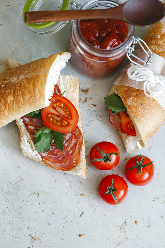 Sandwich near tomatoes and jar