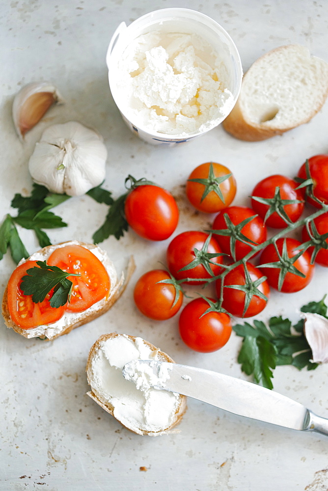 Tomatoes on vine near cream cheese and bread