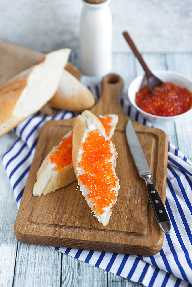 Bread with caviar on cutting board