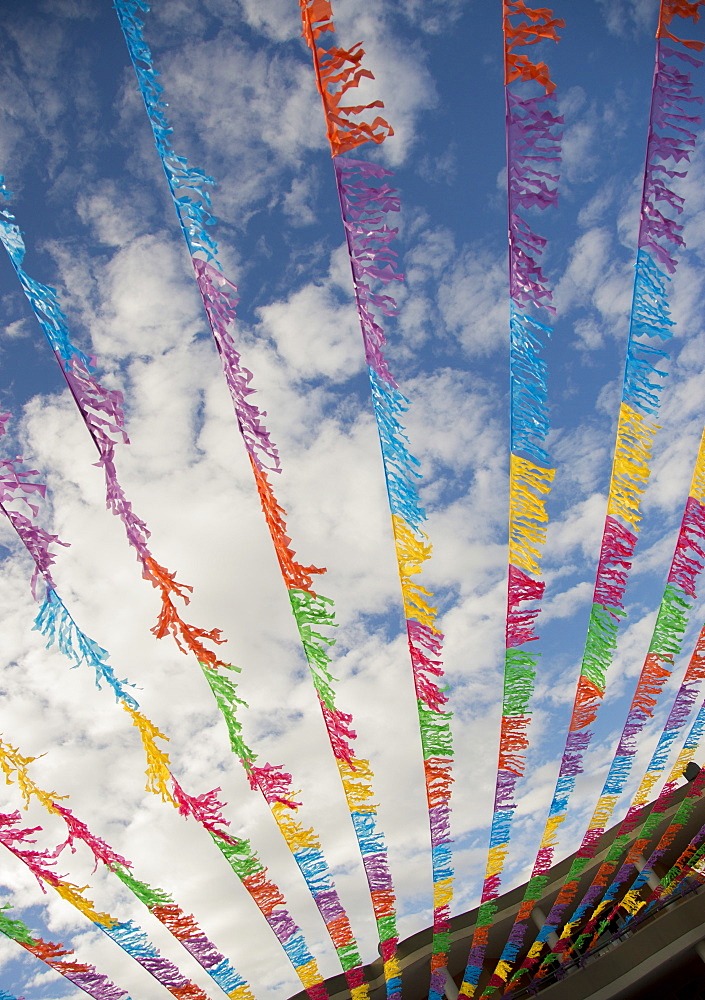 Multicolor flags blowing in wind under blue sky