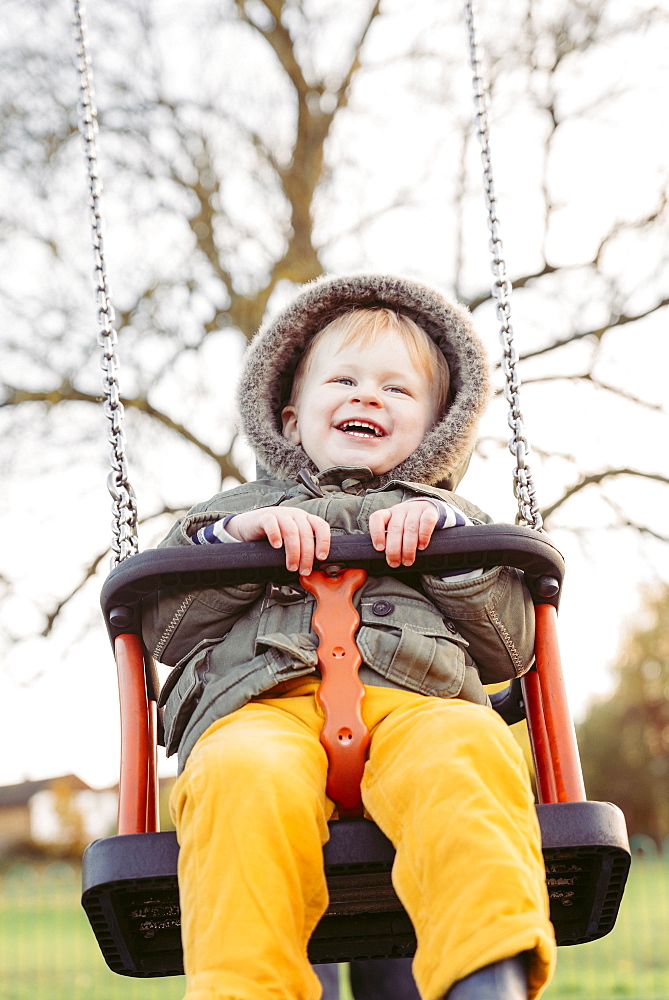 Caucasian boy smiling on swing