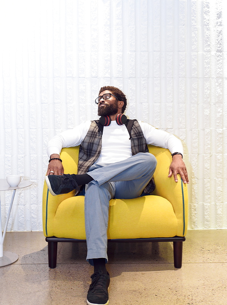 Black man sitting in yellow chair