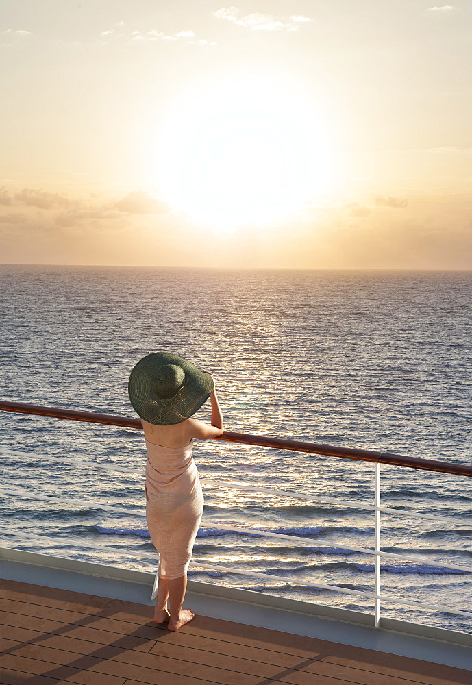 Caucasian woman on boat admiring sunset