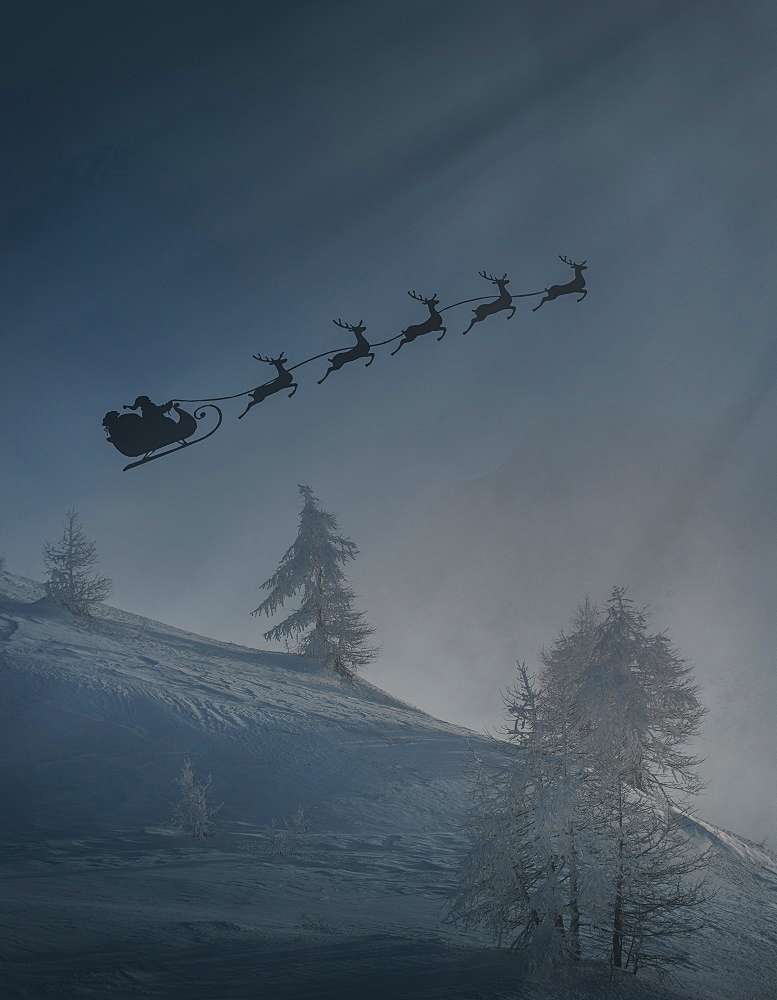 Silhouette of Santa and reindeer flying sleigh in winter