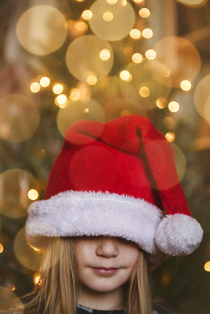 Caucasian girl wearing large Santa hat