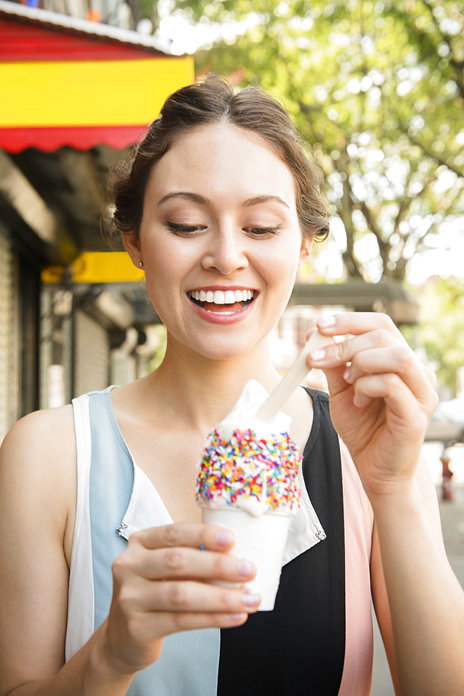 Thai woman eating ice cream in city