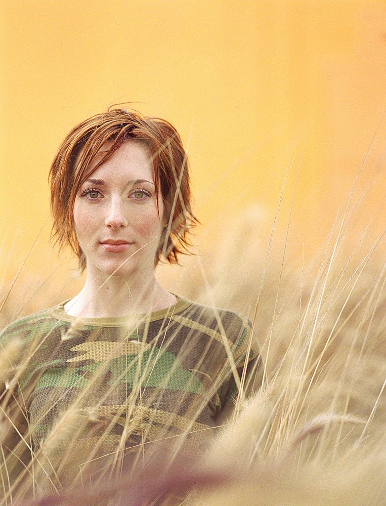 Caucasian woman standing in tall grass