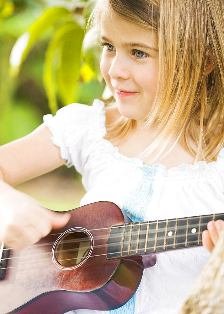 Caucasian girl playing ukulele