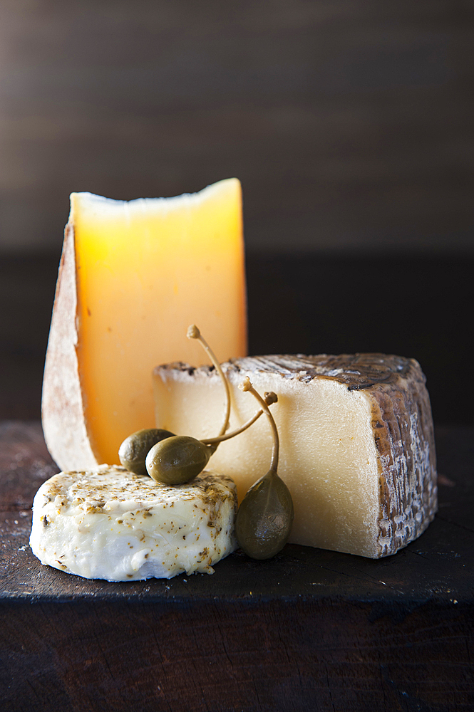 Artisanal cheese and fruit on wooden cutting board