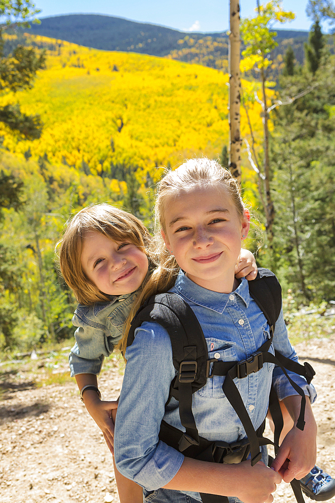 Caucasian girl carrying brother on back