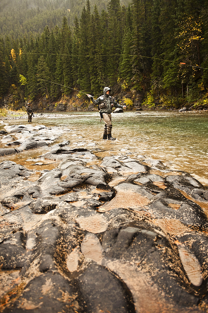 Caucasian men fishing in river