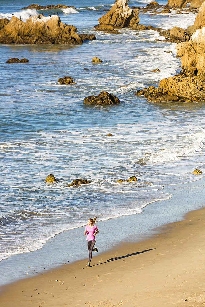 Caucasian woman running on beach