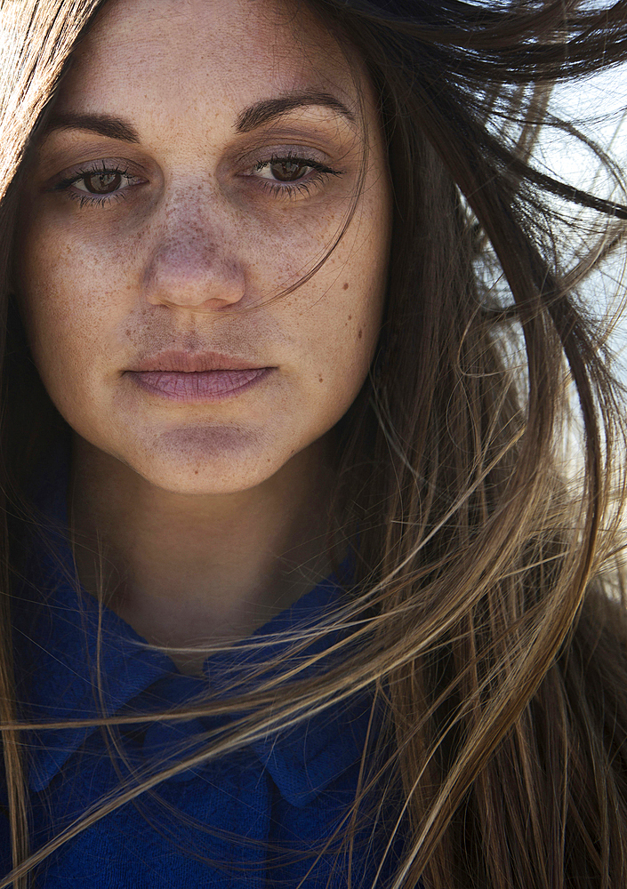 Wind blowing hair of Caucasian woman with freckles