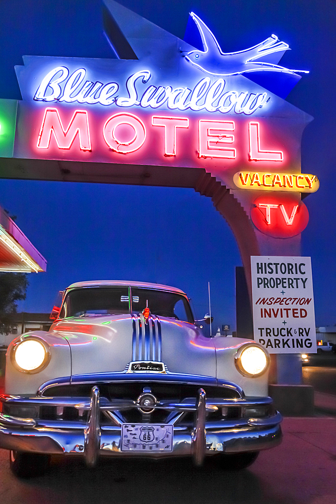 Old-fashioned car in motel parking lot at night