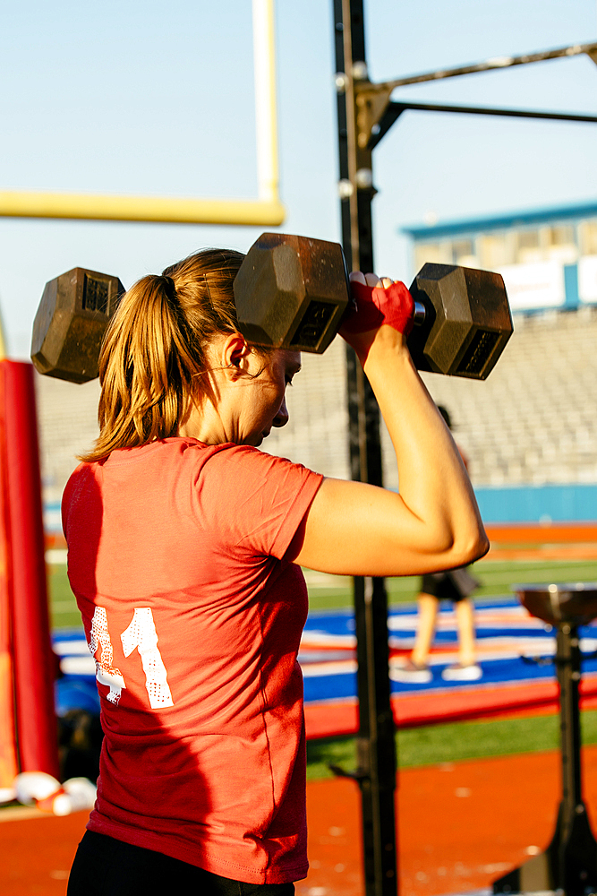 Caucasian woman lifting weights outdoors