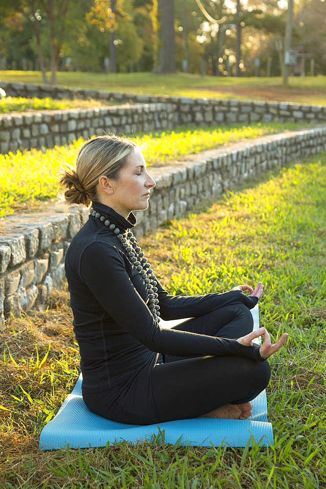 Caucasian woman meditating in park