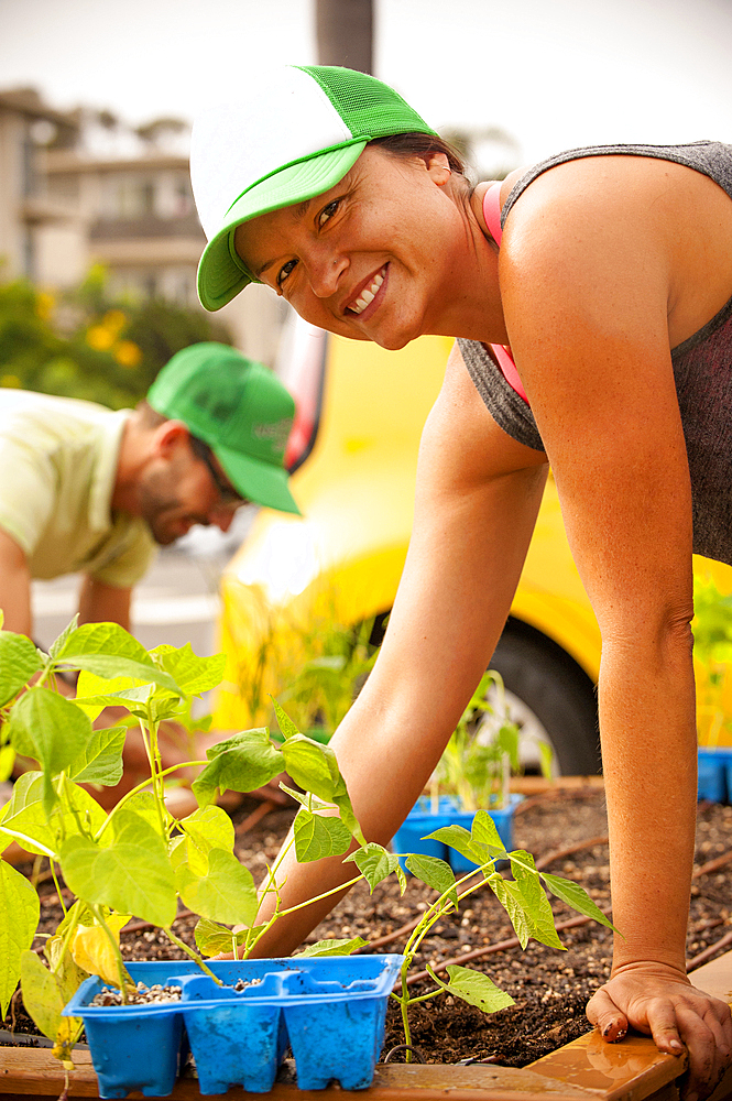 Hispanic couple planting in raised garden