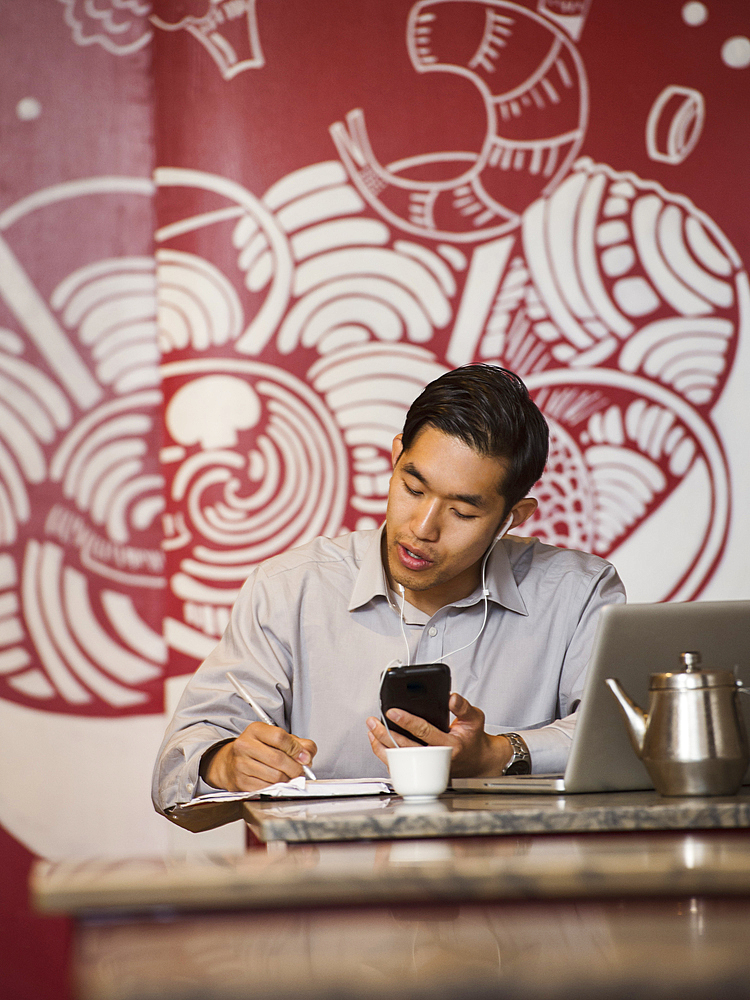 Chinese businessman talking on cell phone in restaurant