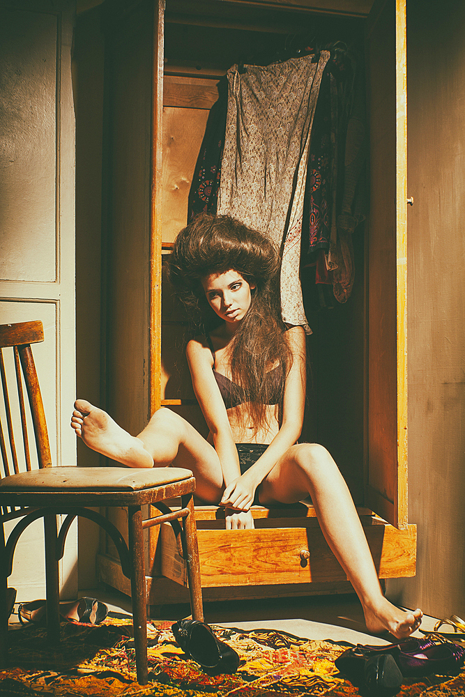 Caucasian woman sitting in wardrobe wearing underwear