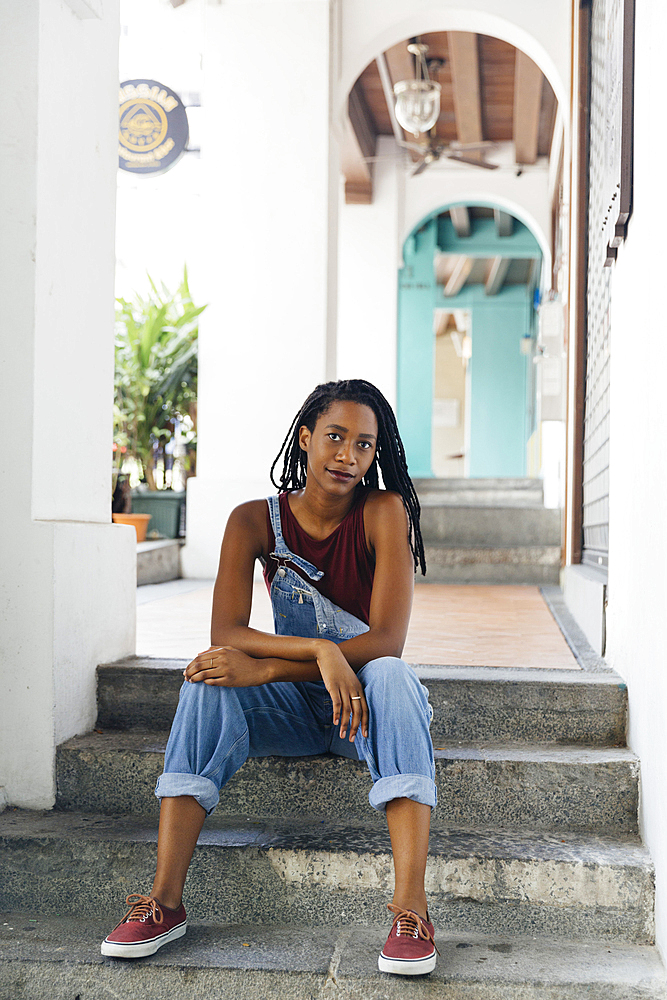 Serious Mixed Race woman sitting on staircase