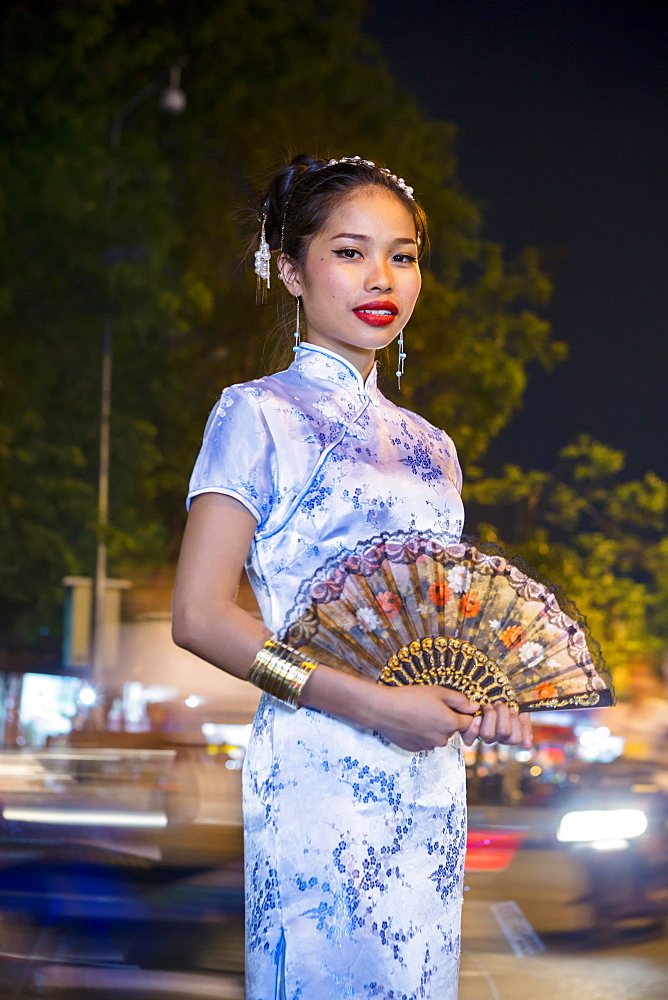 Portrait of Asian woman wearing traditional clothing holding fan