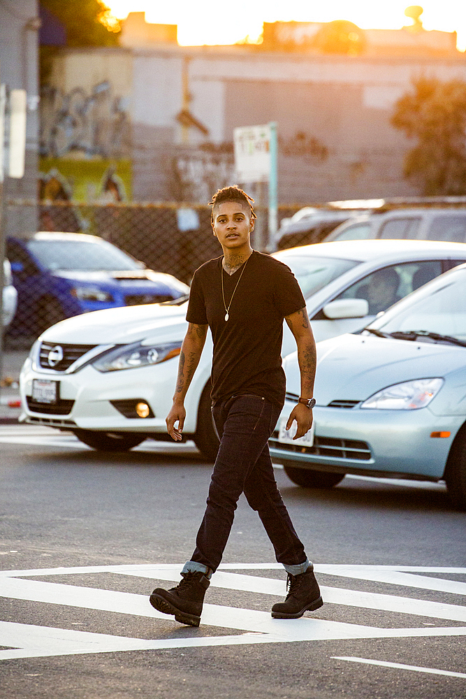 Androgynous Mixed Race woman walking in urban crosswalk