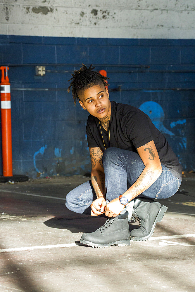 Androgynous Mixed Race woman tying shoelace