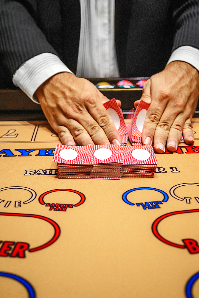 Dealer shuffling cards at baccarat table