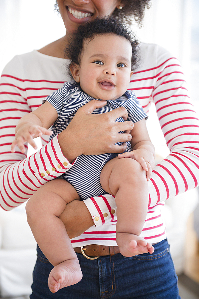 Smiling mother holding baby son