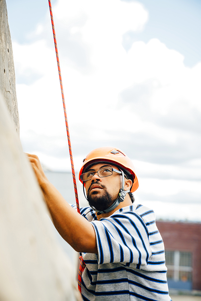 Mixed Race man climbing rock climbing wall