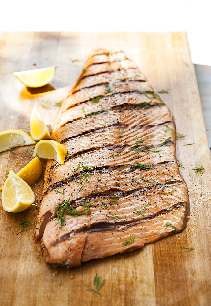 Salmon on cutting board with lemon wedges