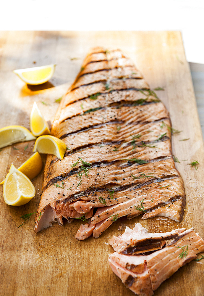 Salmon on cutting board with lemon wedges