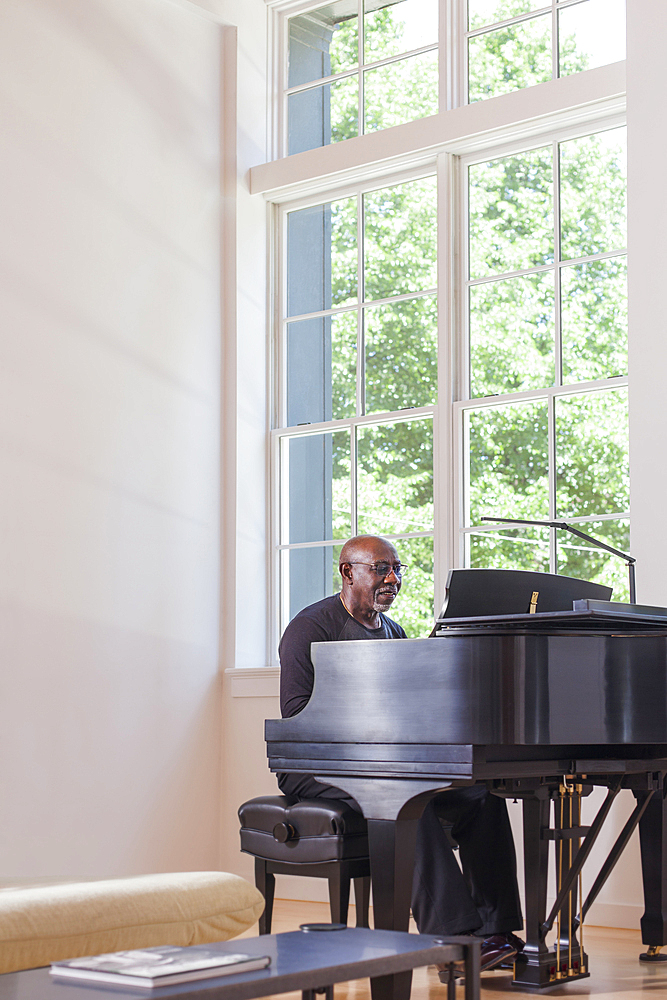 Man playing piano near window